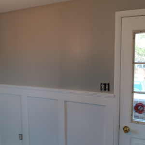 A newly painted wall with white wainscoting and a light brown upper section by Carter's painting in Martinsburg, WV.