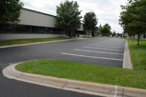 A newly paved parking lot with fresh white line markings completed by Buck Blacktop Inc in Little Canada, MN.