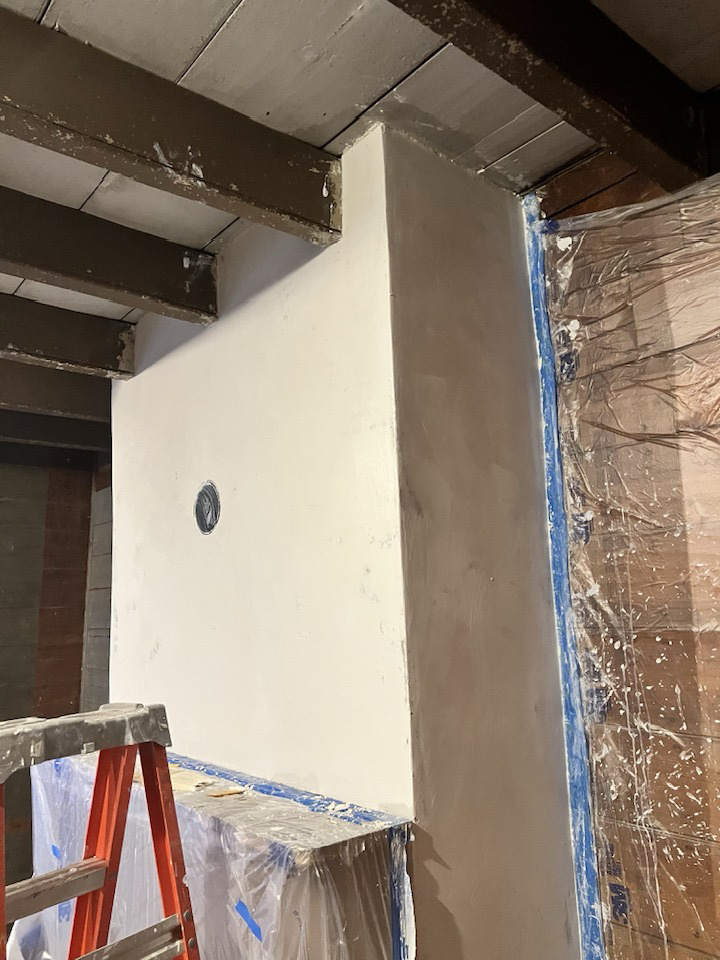A newly plastered wall section with exposed beams, showing handyman work by Eric Aulbach Plastering in Saint Louis, MO.