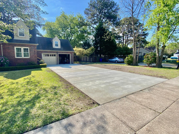 A newly poured concrete driveway leading to a residential garage by McGhee's Concrete in Chesapeake, VA.