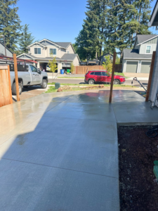 A newly poured concrete driveway and pathway in front of a home by Solid Craftsmen in Gresham, OR.