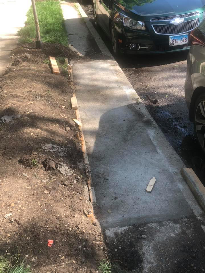 A newly poured concrete sidewalk section with wooden forms in place by Pro Home Solutions in Aiken, SC.