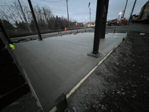 A newly poured concrete slab next to railroad tracks, indicating commercial or industrial work by Moons Concrete & Construction LLC in Chicago, IL.