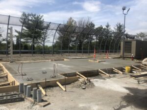 A newly poured concrete slab with formwork and utility conduits installed by Solimini Excavation and Utility in Freetown, MA