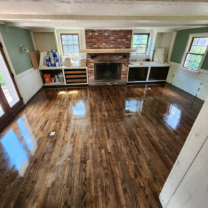 A newly refinished dark hardwood floor in a living room, showcasing quality work by floorzone.inc in Los Angeles, CA.
