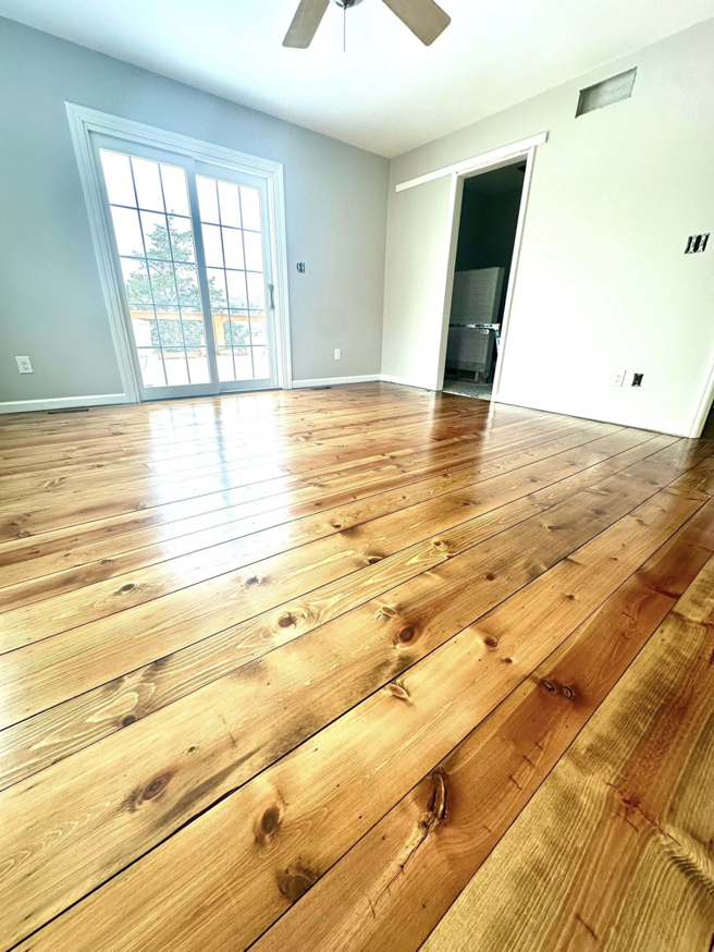 A room featuring newly refinished pine floors with a glossy finish by WoodHaven Floor Refinishing in Georgetown, KY.