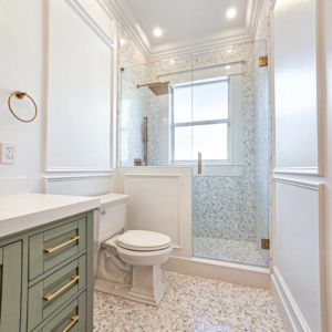 A newly remodeled bathroom featuring a glass shower, modern vanity, and tiled floor by JNY Remodeling INC in Fort Lauderdale, FL.