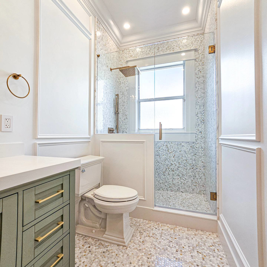 A newly remodeled bathroom featuring a glass shower, modern vanity, and tiled floor by JNY Remodeling INC in Fort Lauderdale, FL.