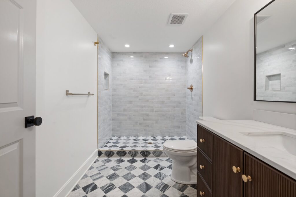 A newly remodeled bathroom featuring a walk-in tiled shower and modern vanity by H4 Construction and Remodeling in Blue Springs, MO.