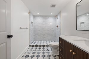A newly remodeled bathroom featuring a walk-in tiled shower and modern vanity by H4 Construction and Remodeling in Blue Springs, MO.