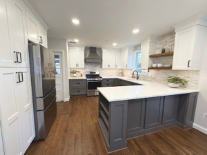 A newly remodeled kitchen featuring white and gray cabinets, new appliances, and a modern backsplash by Chesapeake Premier Remodeling in Baltimore, MD