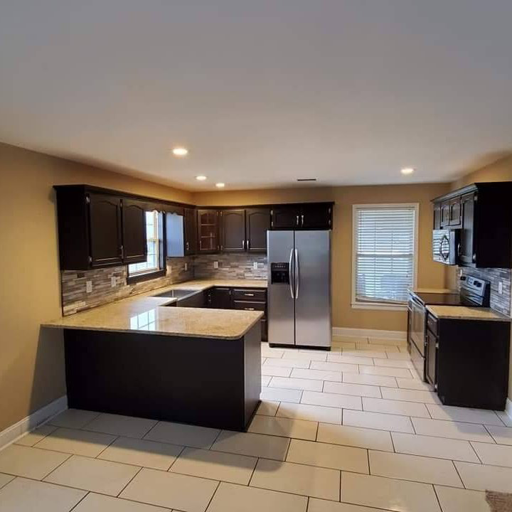 A newly remodeled kitchen with dark cabinets and light countertops by C&M construction, remodeling, handyman services in Lorain, OH.