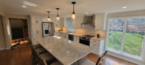 A newly remodeled kitchen with white cabinets and a large island installed by Walker Kitchen Design in Granby, CT.