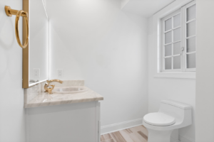 A newly renovated bathroom with a white vanity and gold fixtures by EK Construction, LLC in Philadelphia, PA