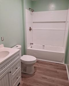A newly renovated bathroom featuring a new vanity, toilet, and shower/tub combo by Honey Don'ts Handyman Service in Twin Falls, ID.