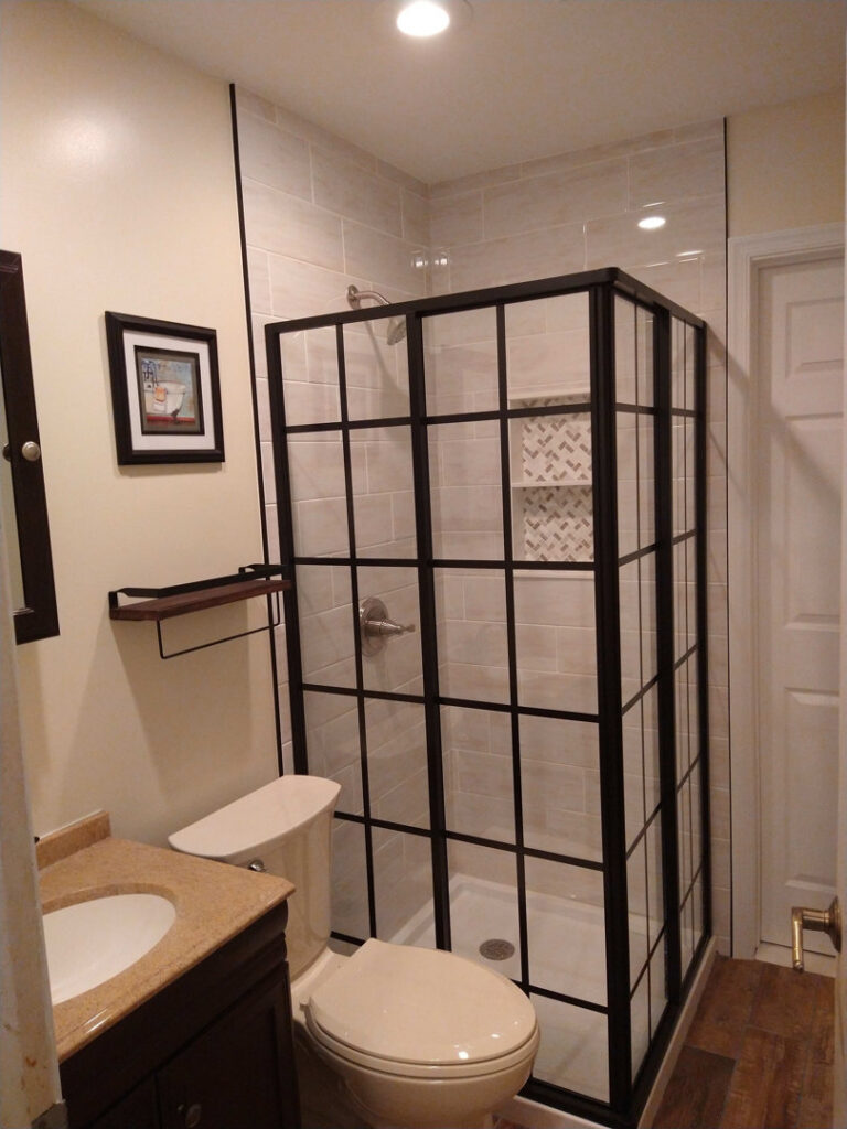A newly renovated bathroom featuring a modern black-framed shower enclosure, completed by Blas Home Remodeling LLC in New Castle, DE.