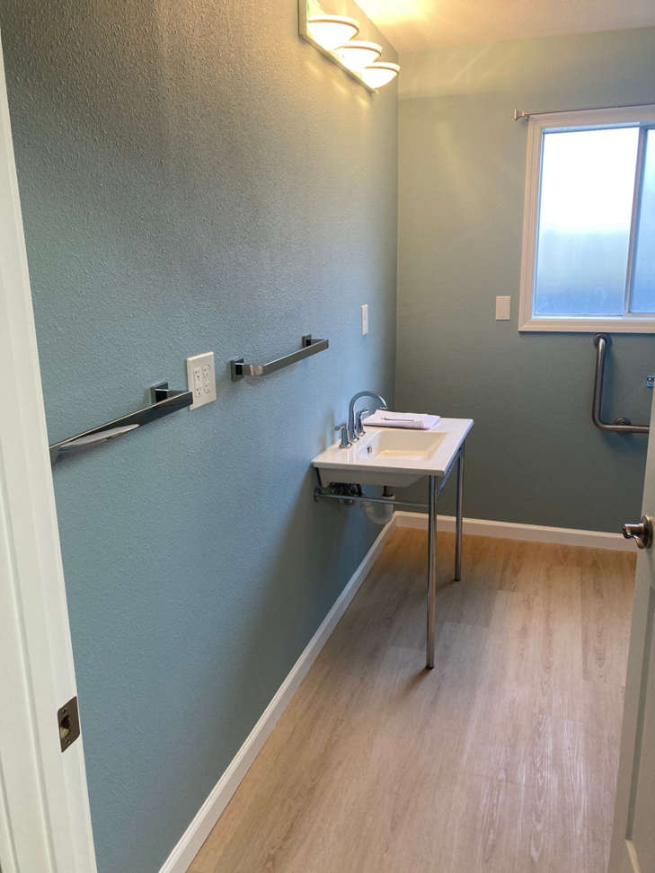 A newly renovated bathroom featuring a modern sink and grab bars installed by Leupitz Contractors Inc in Salem, OR.