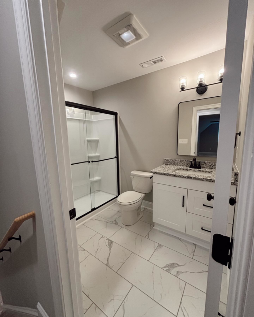 A newly renovated bathroom featuring a modern vanity, shower, and tiled floor by Welcome Home Building Services in Winston-Salem, NC.