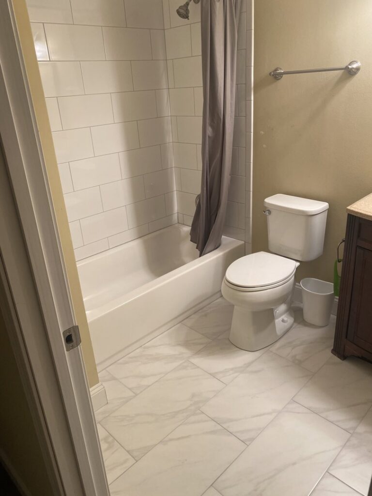 A newly renovated bathroom with white subway tiles in the shower and a modern vanity, completed by Better Than Your Last Handyman in St. Charles, MO.