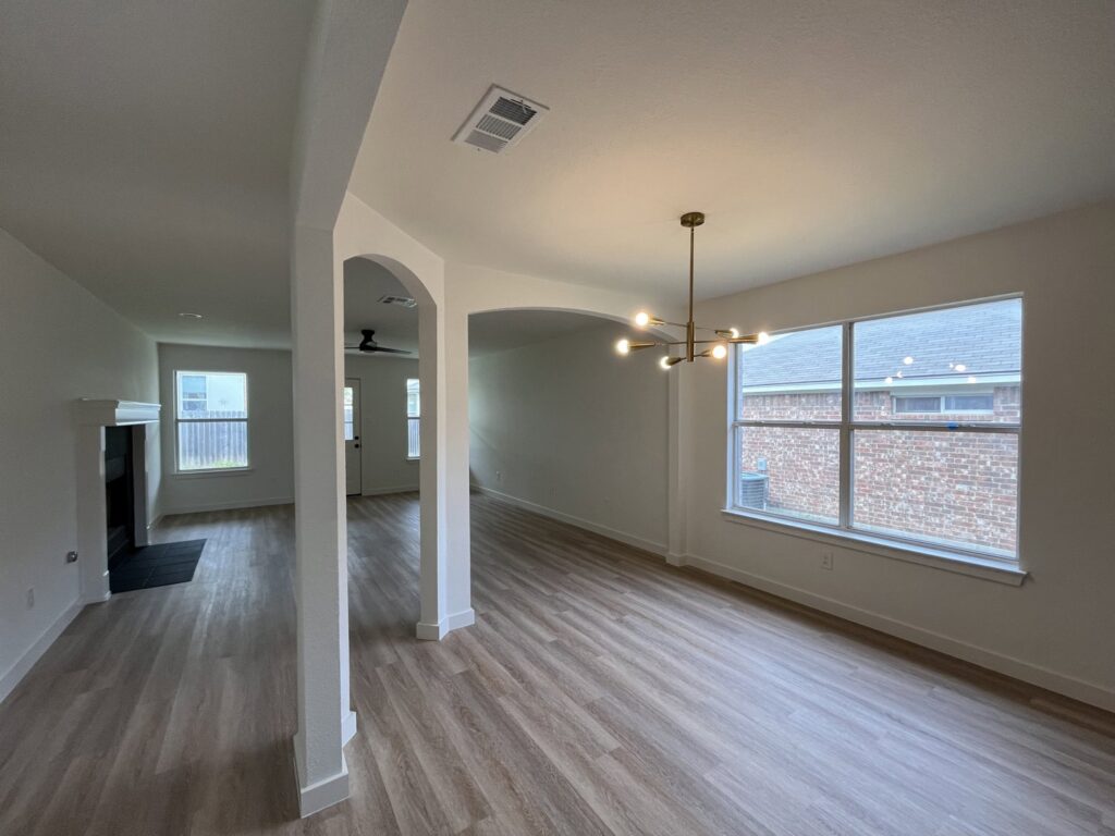 A newly renovated home interior with new flooring and painted walls by San Marcos Drywall and Paint in Austin, TX