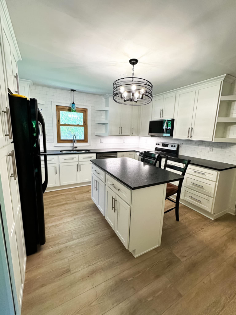 A newly renovated kitchen featuring white cabinets and a black island by Blue Ribbon Renovations in Elizabethtown, KY.