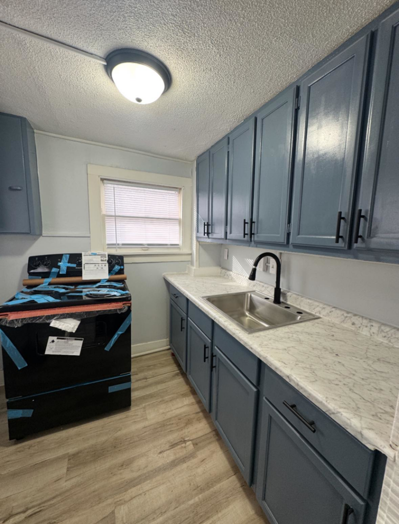 A newly renovated kitchen with blue cabinets and new appliances by John Oliver Rose & Co. in South Bend, IN