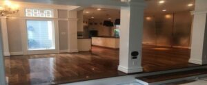 A newly renovated open-plan room featuring gleaming dark hardwood floors, completed by NV Floors LLC in Pittsburgh, PA.