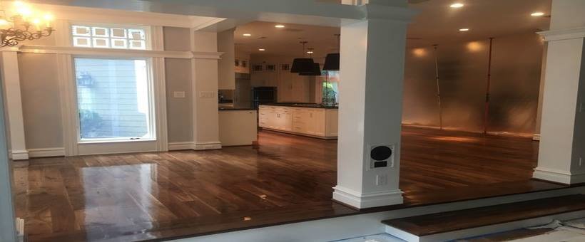 A newly renovated open-plan room featuring gleaming dark hardwood floors, completed by NV Floors LLC in Pittsburgh, PA.