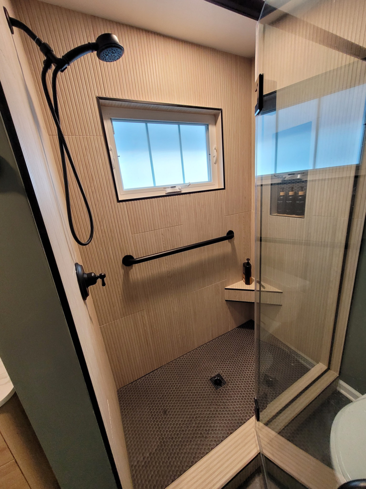 A newly renovated shower with modern fixtures and tiling, completed by Renew Additions & Remodeling, LLC in Columbus, OH.