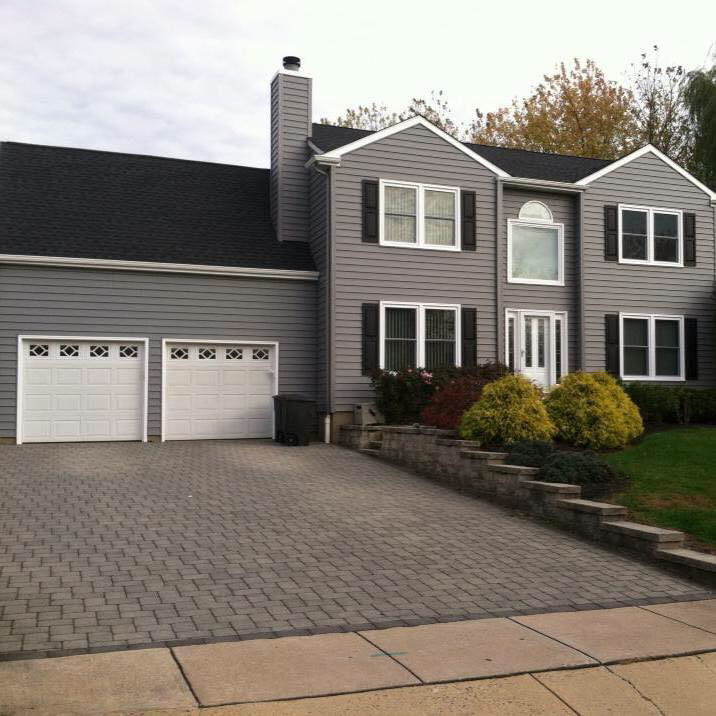 A newly sided house with a new roof and garage doors, showcasing home improvement work by Quality Care Home Improvements in Hamilton, NJ.
