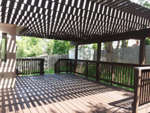 A newly stained wooden deck with a pergola, a completed project by Brauny Home Services, LLC in Arvada, CO