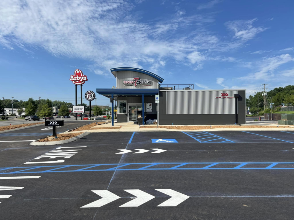 A newly striped parking lot with blue and white markings for 7 Brew Coffee by Marine One Striping in Clarksville, TN.