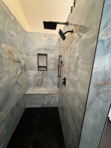 A newly installed, custom-tiled shower with modern black fixtures by Bohannon Custom Tile and Renovation in Virginia Beach, VA.