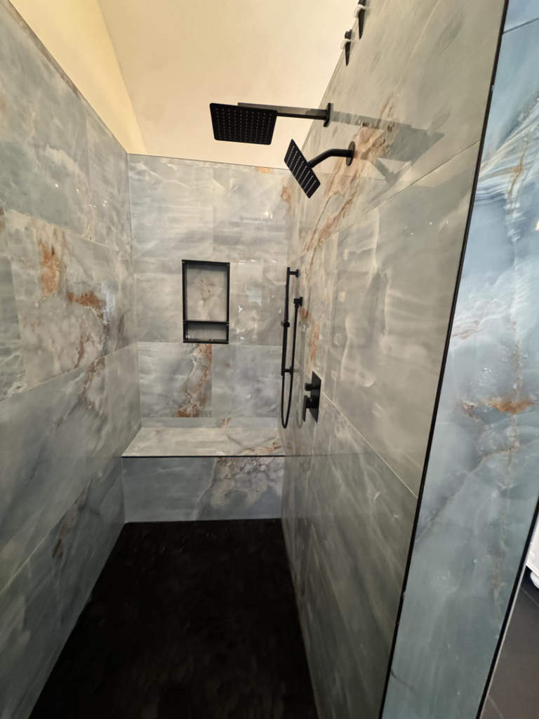 A newly installed, custom-tiled shower with modern black fixtures by Bohannon Custom Tile and Renovation in Virginia Beach, VA.