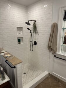 A newly tiled shower with modern black fixtures, installed by Tito's Home Improvement LLC in Stamford, CT.