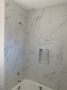 A newly tiled shower and bathtub area, showcasing quality tile installation by Vazquez Quality Construction Inc in Aurora, CO.