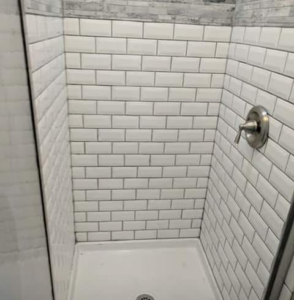 A newly tiled shower stall completed by Handyman Heroes in Roswell, NM, showcasing quality bathroom renovation.