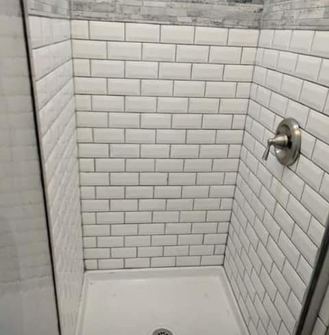 A newly tiled shower stall completed by Handyman Heroes in Roswell, NM, showcasing quality bathroom renovation.