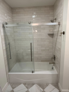 A newly installed tiled shower and tub combo with a glass enclosure by Patriot Tile LLC in Skiatook, OK.