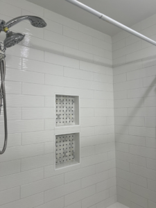 A newly tiled shower with built-in storage niches completed by Gonzalez Services Corp. in Nashville, TN.