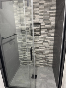 Newly tiled walk-in shower with glass door installed by Castillo Contracting & Remodeling in Broken Arrow, OK.
