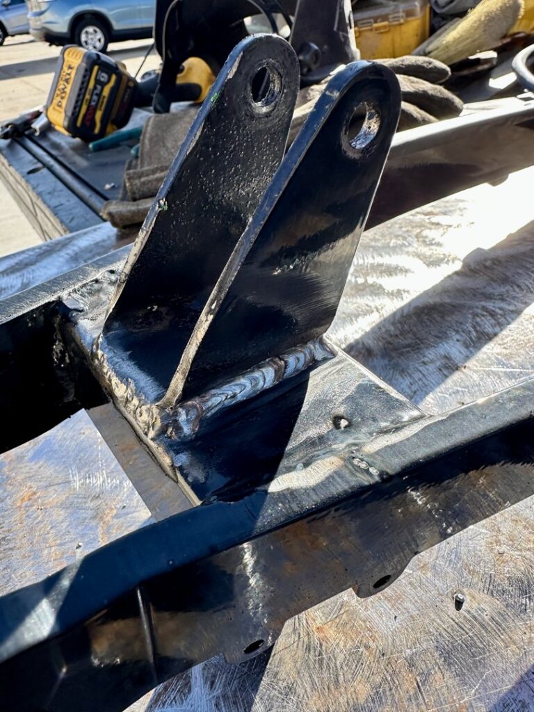 A newly welded and painted black metal bracket, showcasing quality fabrication work by Jeremy's Welding & Handyman in West Jordan, UT.