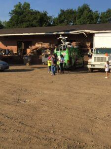 A news van and people gathered at the Queen City Metal Recycling & Salvage facility in Charlotte, NC.