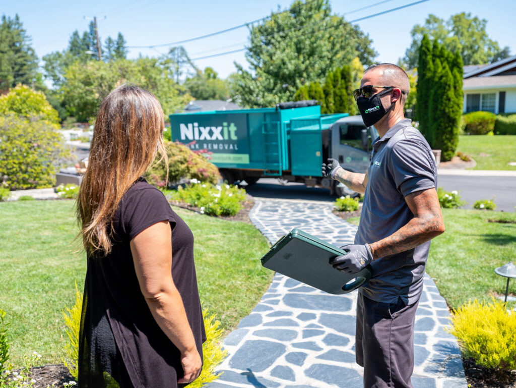A Nixxit Junk Removal employee consulting with a customer in front of their truck in Castro Valley, CA.