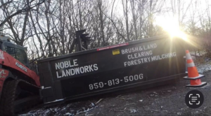 A Kubota skid steer next to a Noble Landworks dumpster for brush and land clearing in Georgetown, KY.