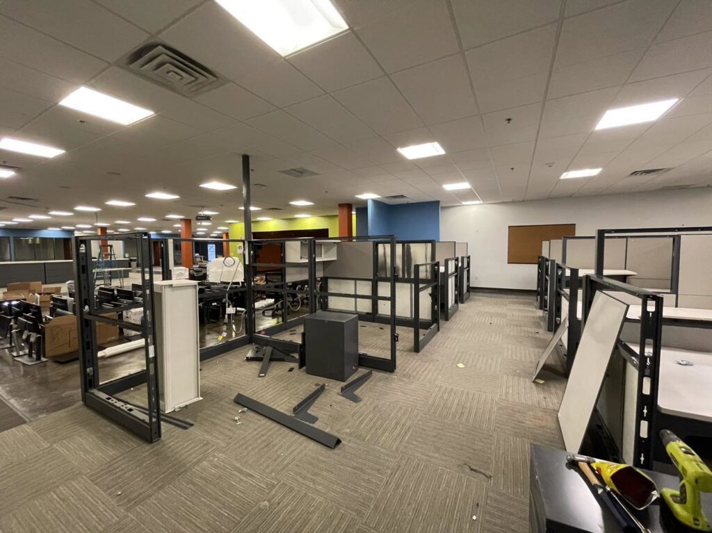 An office space with disassembled cubicles and debris, indicating an office cleanout and junk removal service by G.I. HAUL Austin, TX.
