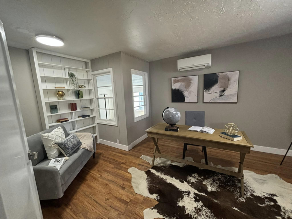 An office with new hardwood flooring, built-in bookshelf, and mini-split AC unit installed by A to Z Remodeling llc in Gresham, OR.