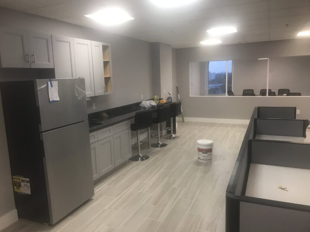 An office kitchenette installation with new cabinets and a refrigerator by BRM Construction in Miami, FL.