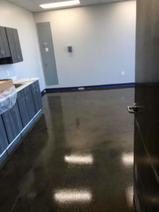 A dark polished concrete floor in an office or utility room by Kentucky Decorative Concrete in Nicholasville, KY.