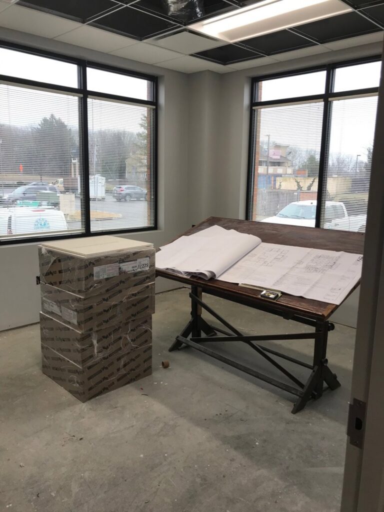 Blueprints on a drafting table at an office renovation site by Pharos Contracting Company Inc. in Newark, NJ